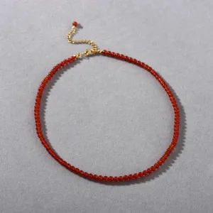 Detailansicht der eleganten roten Achat Perlenkette mit polierten roten Perlen und goldfarbener Kette.