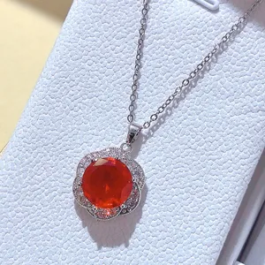 Primo piano di una collana con ciondolo in pietra preziosa rossa con alone di pavé.