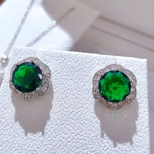 Raffinati orecchini a lobo floreali con gemma verde e strass scintillanti dettagli.