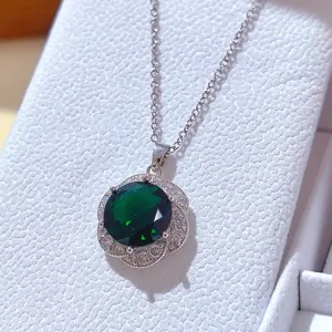 Primo piano di collana in argento con ciondolo di pietra verde e diamanti luminosi.