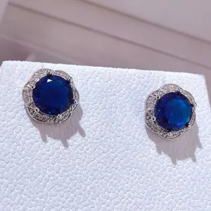 Squisite orecchini con pietra preziosa blu e alone di zirconi lucidi, design floreale.