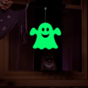 Halloween glowing ghost window decoration detail showing bright green luminous effect at night.
