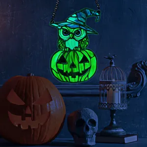 Close-up of the glowing Halloween owl and pumpkin acrylic hanging decor in a moody scene.