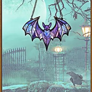 Close-up detail of the Halloween stained acrylic bat hanging ornament with spooky moonlit background.