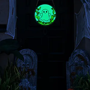 Close-up detail of glowing Halloween ghost hanging decoration in dark spooky themed scene.