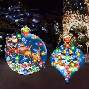 Close up of illuminated LED Christmas garden stakes featuring festive winter village scenes.
