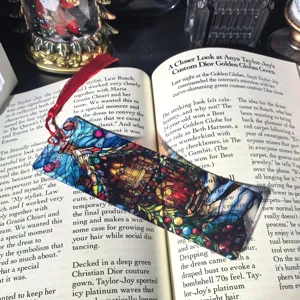 Transparent acrylic bookmark with red tassel, stained glass art design for students.