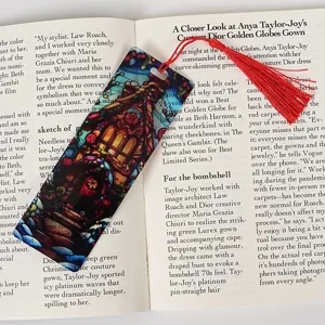 Transparent acrylic bookmark with red tassel, colorful stained glass architectural design for reading.