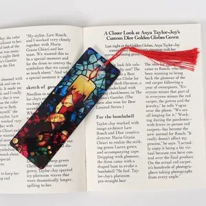 Transparent acrylic bookmark with red tassel, stained glass candle design for reading lovers.
