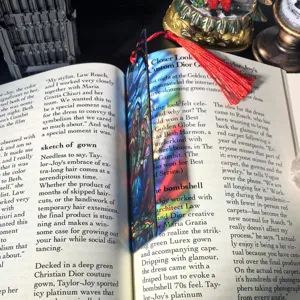 Transparent acrylic bookmark with colorful stained glass pattern and red tassel for reading.