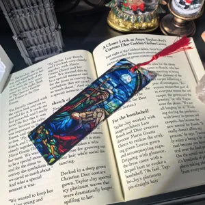 Transparent acrylic bookmark with stained glass art and red tassel, ideal for reading.