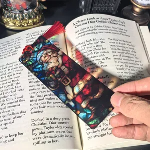 Translucent acrylic Christmas bookmark with stained glass Santa Claus design and red tassel.
