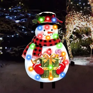 Detailaufnahme des leuchtenden Weihnachts-Schneemanns mit bunten Lichtern und Geschenk.