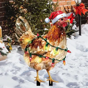 Detalle de la estaca de jardin con gallina de Navidad iluminada en la nieve invernal.