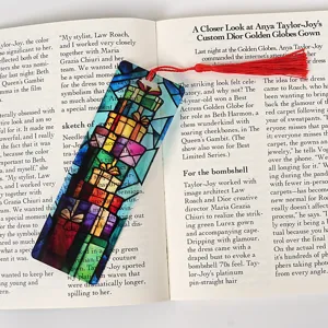Transparent acrylic Christmas bookmark featuring colorful gift box design and red tassel accent.