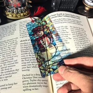 Christmas clear acrylic bookmark with colorful snowman design and red tassel for reading.
