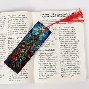 Transparent acrylic bookmark with red tassel, colorful stained glass design for reading.
