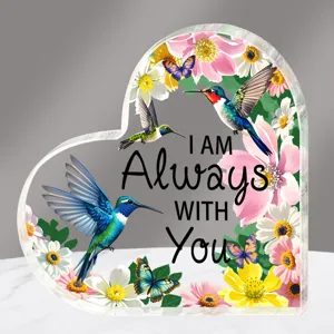Detailopname van helder acryl hart ornament met bloemen en kolibrie print en mooie tekst.