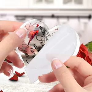 Gedetailleerd overzicht van helder acryl hart ornament met rode kardinaal design citaat.
