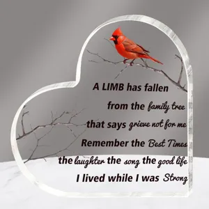 Detailopname van transparante acryl hart memorial plaque met kardinaal en gedicht.