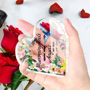 Close-up van helder acryl hartvormig ornament met kolibri en bloemen print ontwerp.