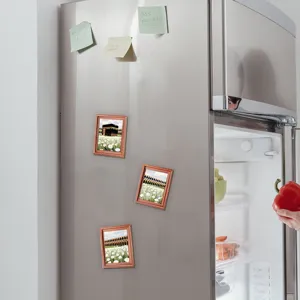 Detail shot of Middle Eastern architectural fridge magnets with wooden frames on a metal fridge.
