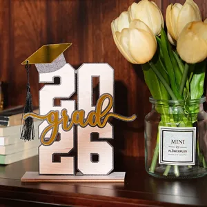 Dettaglio decorazione da tavola in legno per laurea 2026, elegante centrotavola per festa.