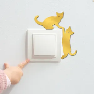 Detail shot of gold mirror acrylic cat wall sticker decorating a light switch on white wall.