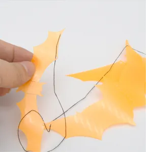Gros plan de décoration de guirlande de chauve-souris en plastique orange, détail.