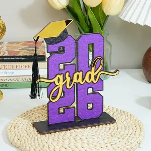Centrotavola in legno di laurea 2026 con cappello dorato a specchio e numeri viola per festa.
