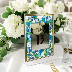 Stained glass style acrylic table number sign closeup, blue flower wedding decor detail.