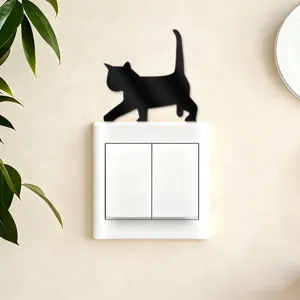 Acrylic cat switch sticker detail shot, featuring a cute black feline wall decal on a white outlet.