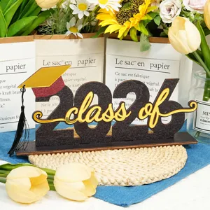 Dettaglio della decorazione da tavola in legno per la laurea 2026 con il cappello.