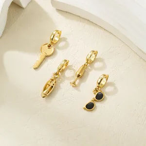 Vue détaillée de pendentifs breloques DIY en acier inoxydable doré aux formes amusantes.