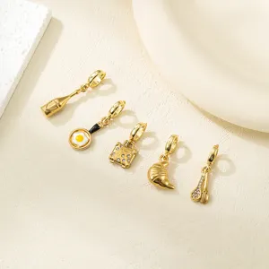 Vue rapprochée de divers charms alimentaires et lifestyle plaqués or pour bijoux DIY.