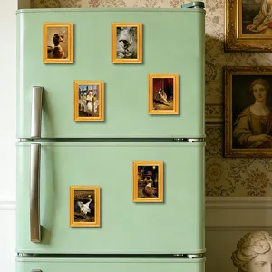 Close-up of funny duck and goose fridge magnets in vintage gold frames on retro green fridge.
