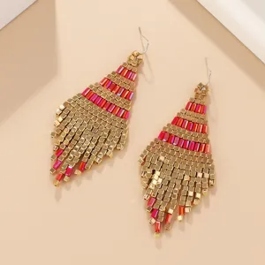 Χειροποίητα boho σκουλαρίκια με χάντρες και κομψές μεταλλικές λεπτομέρειες σε έντονο ροζ.