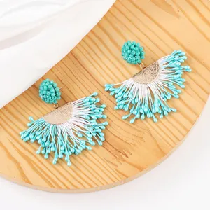 Handmade turquoise beaded tassel earrings featuring gold tone half-circle details.