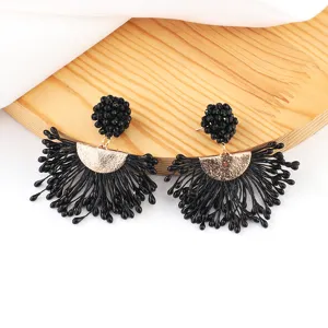 Handmade black beaded tassel earrings detail, elegant fan shape design with gold accent.