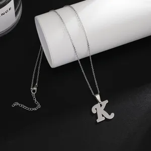 Stainless steel letter K pendant necklace detail, minimalist style, delicate chain.
