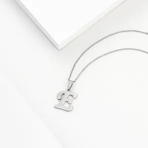 Closeup detail of a minimalist stainless steel letter E pendant necklace on white background.
