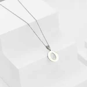 Stainless steel letter O pendant necklace detail close up view, elegant jewelry accessory.