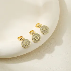 Detail closeup of gold paved alphabet letter U O Y pendant charms for DIY jewelry making accessories.