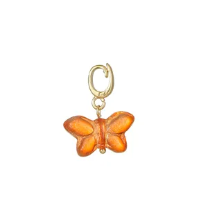 Orange glass butterfly pendant charm detail view, handmade DIY jewelry accessory close up.