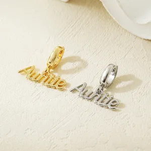 Close-up detail shot of gold and silver tone Auntie letter charms, stylish DIY jewelry accessory.