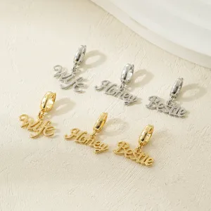 Close-up detail of trendy English word pendant charms in gold and silver, perfect for DIY jewelry.