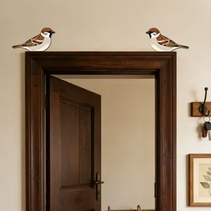 Dettaglio ravvicinato di decorazioni in legno a forma di passero posizionate sulla porta.