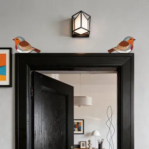 Primo piano di decorazioni in legno a forma di pettirosso per angoli di porte su una cornice nera.