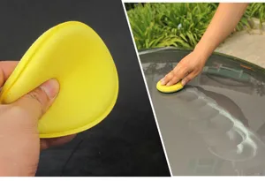 Detail view of soft yellow car waxing sponge, showing texture and practical use on vehicle paint.