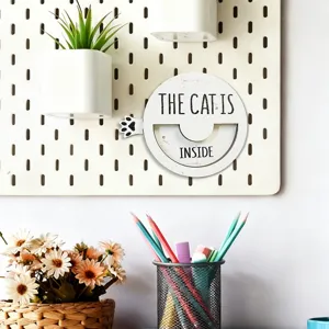 Close-up detail of wooden magnetic cat status sign with rotating paw pointer design.